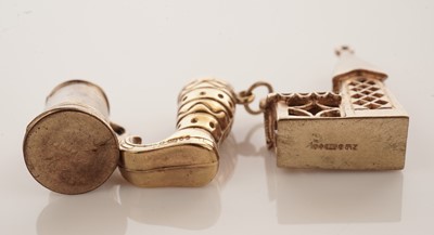 Lot 20 - A collection of 9ct yellow gold charms; with a gilt metal charm