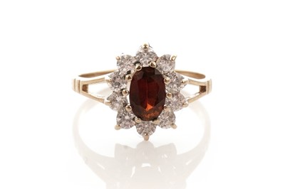 Lot 24 - A garnet and white stone cluster dress ring