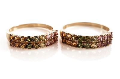 Lot 117 - A pair of coloured stone set half hoop eternity rings