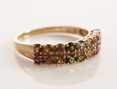Lot 117 - A pair of coloured stone set half hoop eternity rings