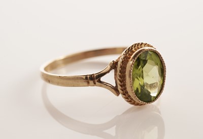 Lot 134 - A peridot single stone ring; and another ring