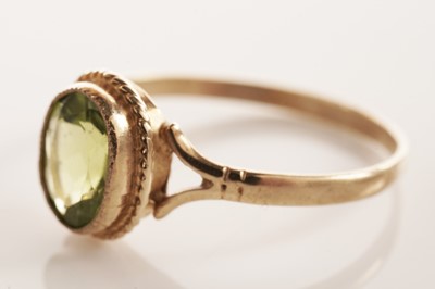 Lot 134 - A peridot single stone ring; and another ring