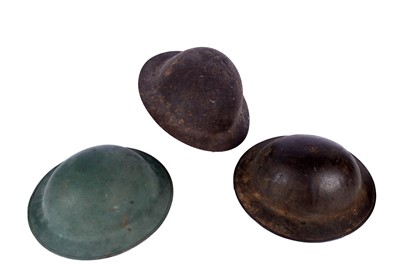 Lot 191 - Two Brodie helmets; and another