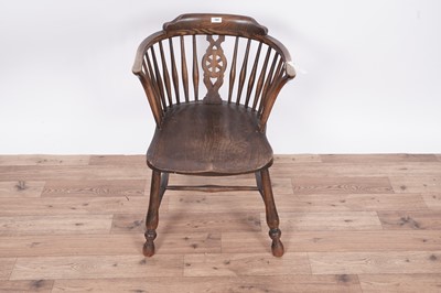 Lot 104 - An early 20th Century beach ash and elm spindle back solid seat armchair