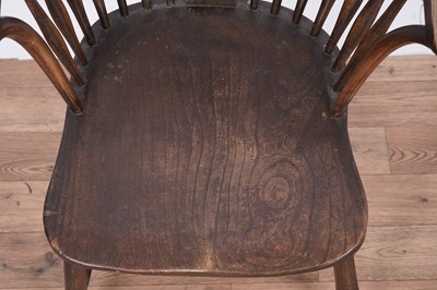 Lot 104 - An early 20th Century beach ash and elm spindle back solid seat armchair