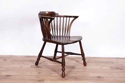Lot 104 - An early 20th Century beach ash and elm spindle back solid seat armchair