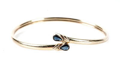 Lot 173 - A sapphire set crossover bangle