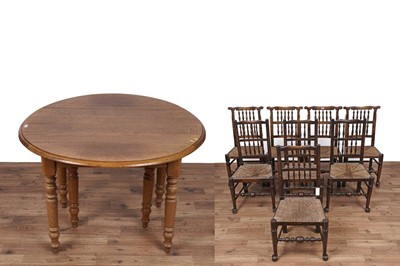 Lot 447 - An Oak drop leaf extending dining table and eight chairs