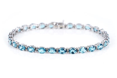 Lot 671 - A topaz and diamond line bracelet