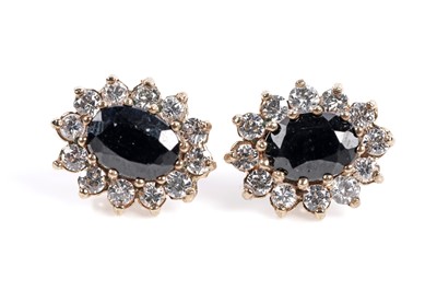 Lot 645 - A pair of sapphire and white stone cluster earrings