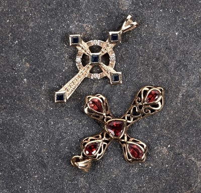 Lot 687 - A sapphire and diamond crucifix pendant and a garnet crucifix pendant