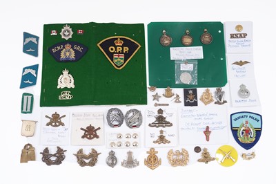 Lot 200 - A selection of foreign and commonwealth military cap badges, buttons and other items