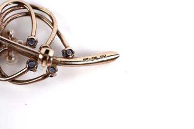 Lot 518 - A sapphire and pearl stylized sprig brooch