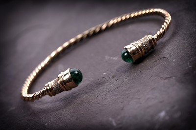 Lot 679 - An emerald, diamond gold bangle