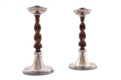 Lot 32 - A pair of arts and crafts silver mounted wooden candlesticks