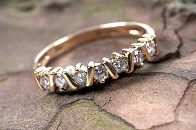 Lot 204 - A seven stone diamond half-hoop eternity ring