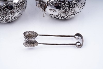 Lot 160 - A late 19th Century Chinese silver three-piece tea service; and a pair of silver sugar tongs