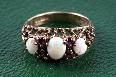 Lot 77 - A 1970's three-stone opal and ruby ring