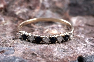 Lot 545 - A sapphire and diamond half hoop eternity ring