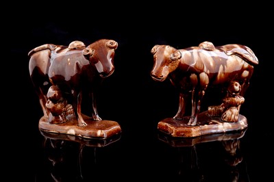 Lot 372 - A pair of treacle glaze cow creamers