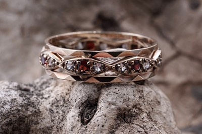 Lot 133 - A 1970s Modernist garnet and white spinel eternity ring