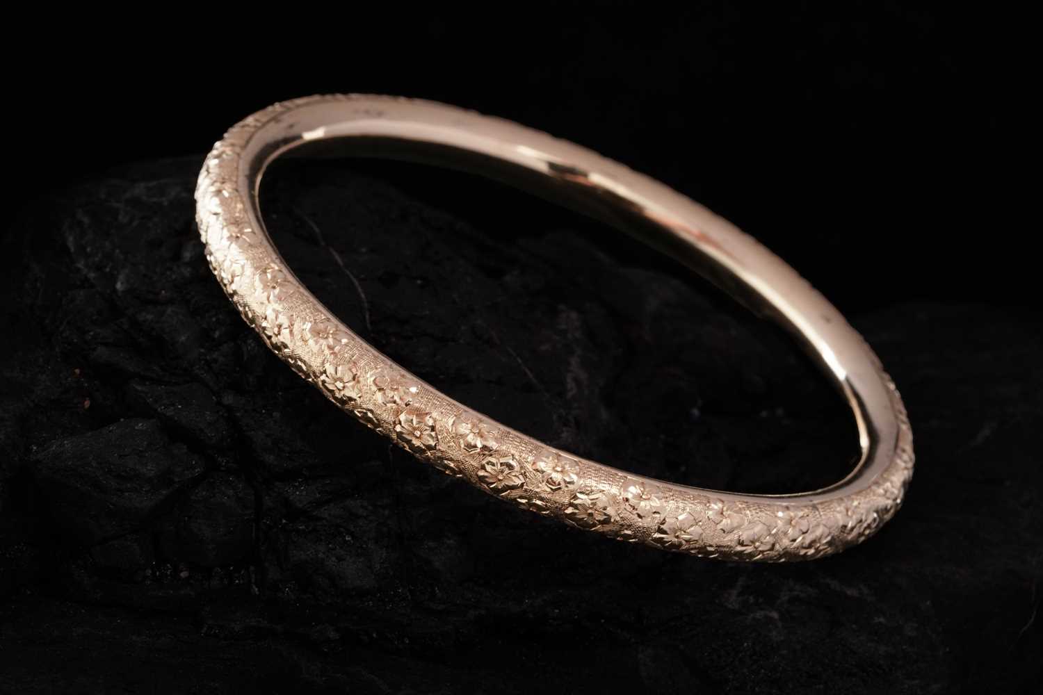 Lot 281 - An early 20th Century 14ct gold bangle with engraved violet flowers