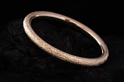 Lot 281 - An early 20th Century 14ct gold bangle with engraved violet flowers