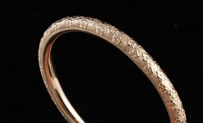 Lot 281 - An early 20th Century 14ct gold bangle with engraved violet flowers
