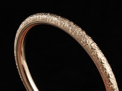 Lot 281 - An early 20th Century 14ct gold bangle with engraved violet flowers