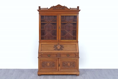 Lot 22 - Robson & Sons Newcastle upon Tyne: an early 20th Century carved oak bureau bookcase