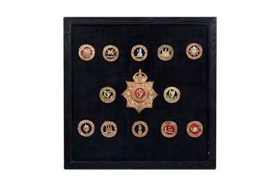 Lot 183 - A display of British regimental helmet badge centres and badge