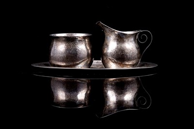 Lot 285 - A 1940s silver handmade Arts and Crafts style sugar and cream jug on stand