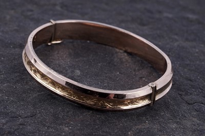 Lot 2 - A Great War period 9ct rose and yellow gold hinged bangle