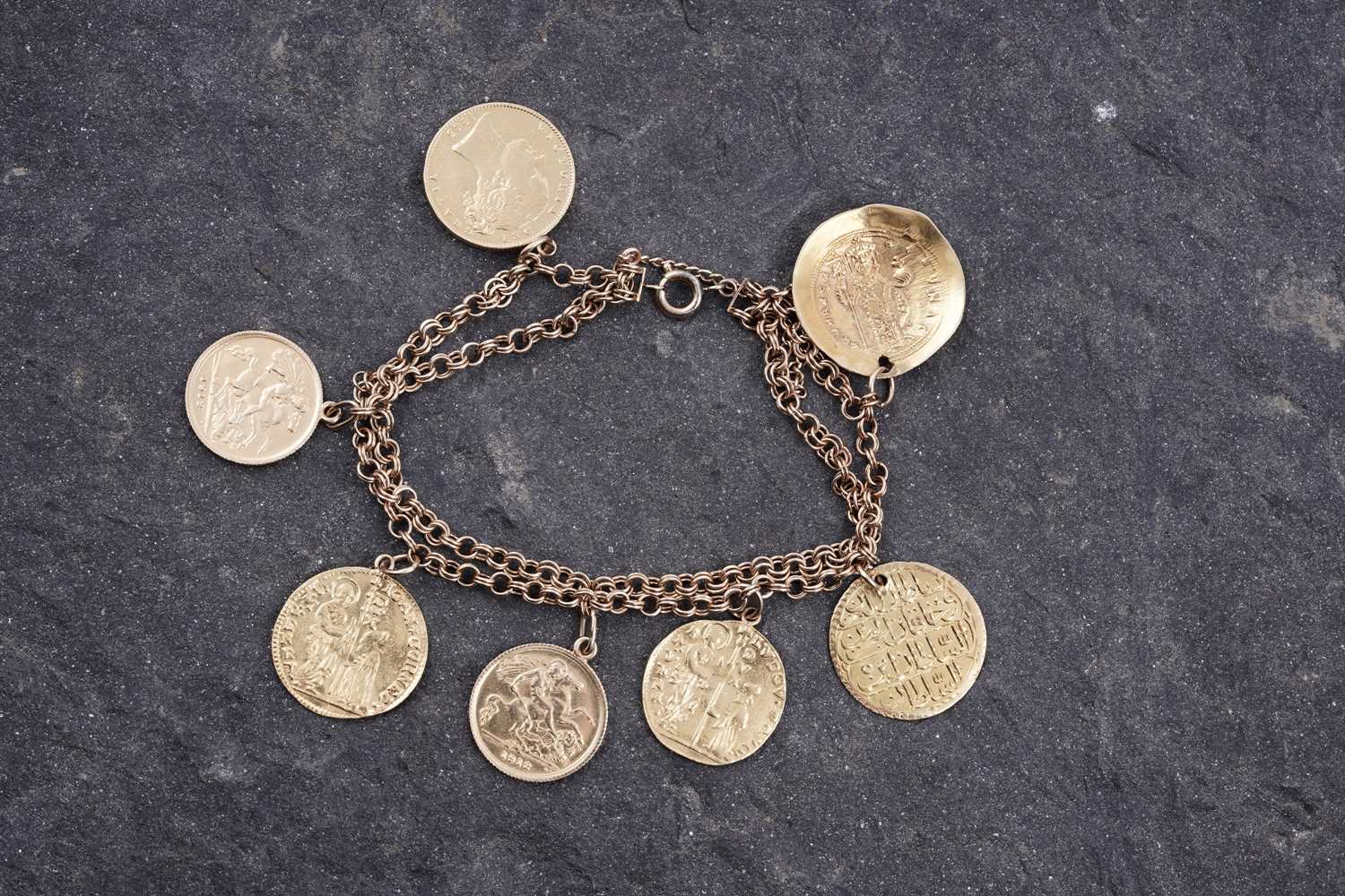 Lot 296 - A fancy figaro-link bracelet; and seven pendant coins