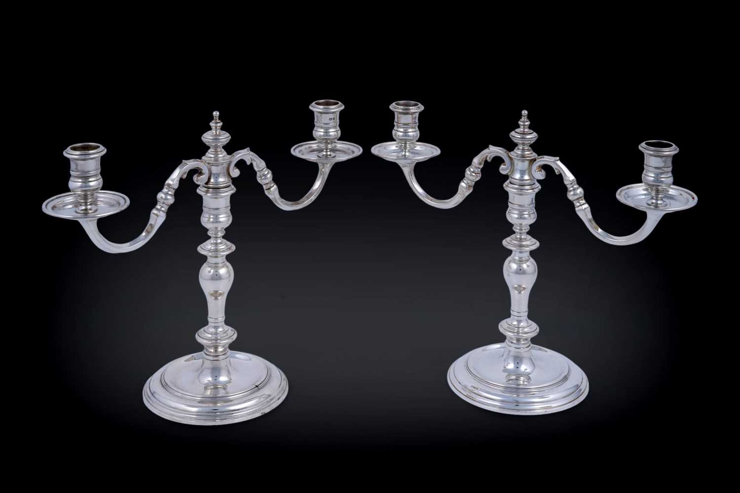 Lot 9 - A matched pair of Elizabeth II cast silver twin-light candelabra