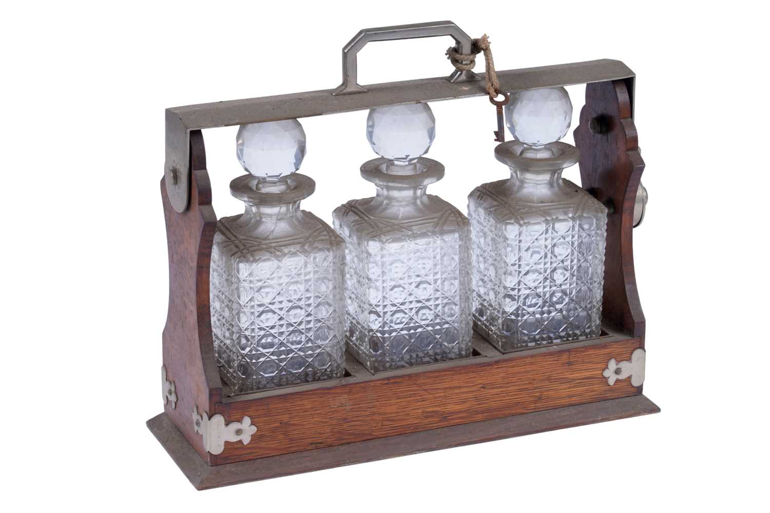 Lot 218 - An Edwardian oak three bottle tantalus