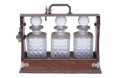 Lot 218 - An Edwardian oak three bottle tantalus
