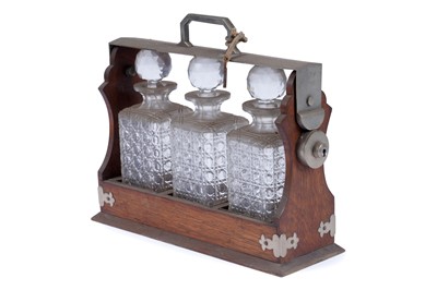 Lot 218 - An Edwardian oak three bottle tantalus