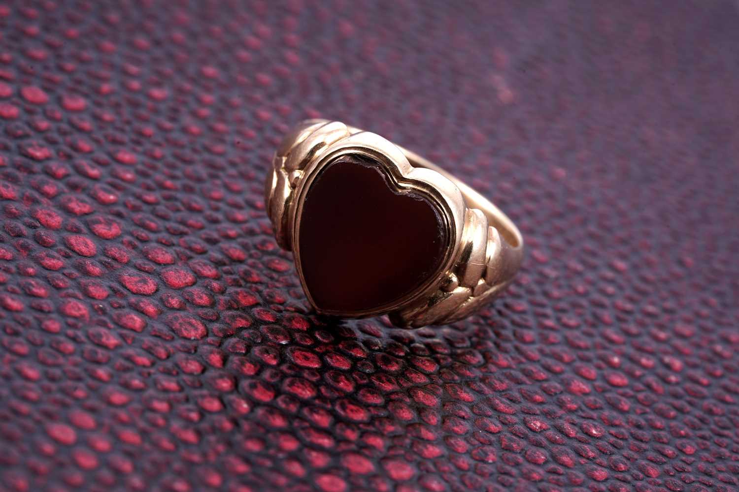 Lot 84 - An Edwardian loveheart pattern carnelian signet ring
