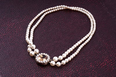 Lot 474 - A two-row cultured pearl necklace with golden topaz set clasp