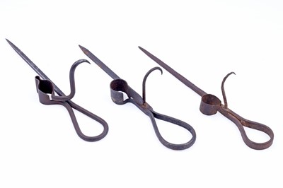 Lot 207 - Two 19th Century wrought iron ‘Sticking Tommy’ candle holders; and another