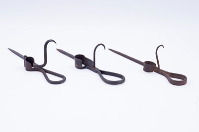 Lot 207 - Two 19th Century wrought iron ‘Sticking Tommy’ candle holders; and another