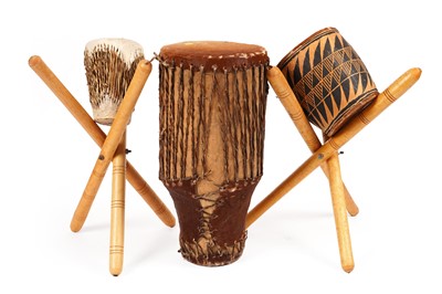Lot 292 - Three tribal animal skin drums; and folding stands