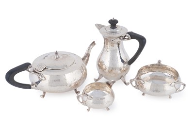 Lot 121 - A George V silver arts and crafts four-piece tea service; and matching hot water jug