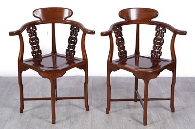 Lot 44 - A pair of Oriental stained hardwood corner armchairs