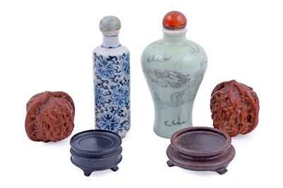 Lot 328 - Two Chinese snuff bottles; and two carved walnuts, with stands