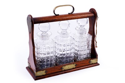 Lot 182 - An Edwardian oak three bottle tantalus