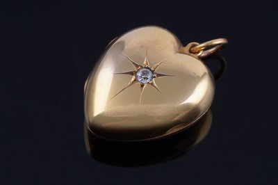 Lot 378 - An Edwardian love heart pattern locket set with a solitaire old-cut diamond