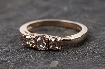 Lot 109 - A three-stone champagne diamond ring