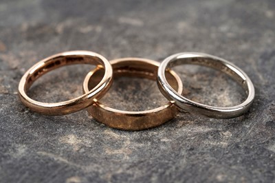 Lot 127 - Three gold wedding bands, including one of 18ct white gold